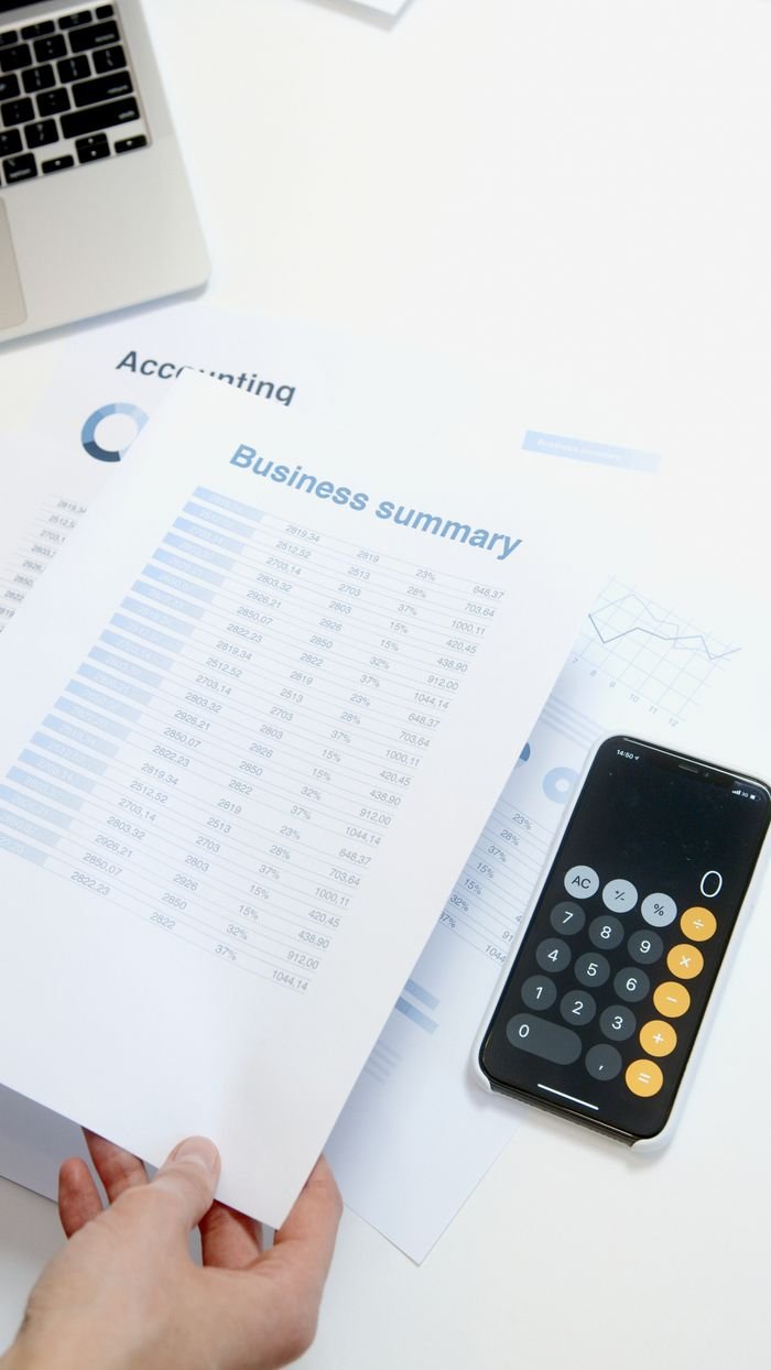 Services-03 Business summary sheet with a calculator on a desk for financial analysis.
