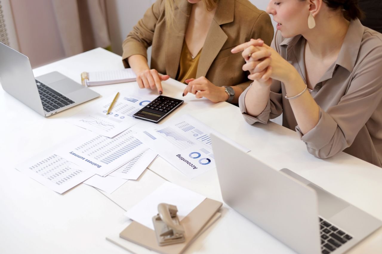 digital Two professionals collaborating on financial documents in a modern office setting.